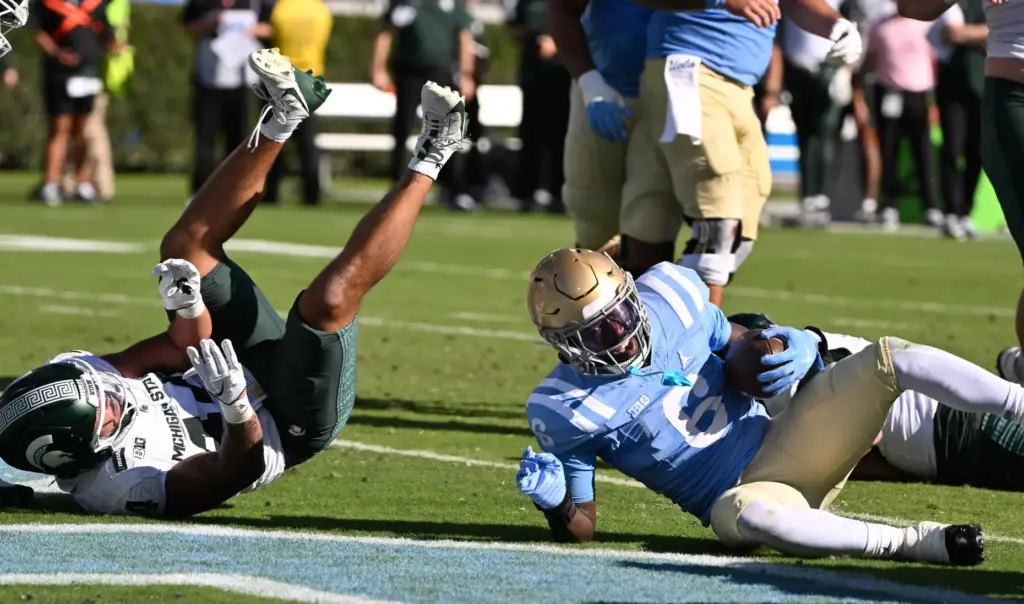 UCLA running back Anthony Woods (6) dives for a 4-yard...