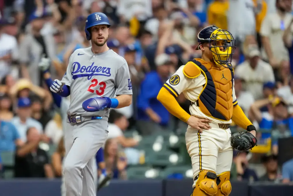 The Dodgers’ Kyle Tucker, left, scores on a throwing error...