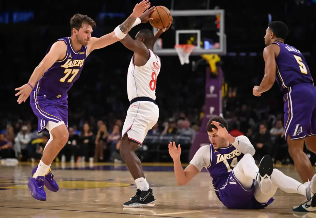 Clippers guard Kris Dunn holds the ball as Lakers star...