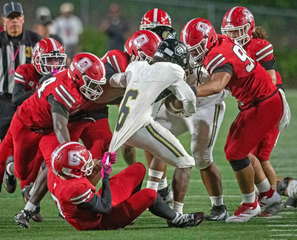 Serviteâs Benjamin Harris (6) finds himself surrounded by Orange Lutheran...