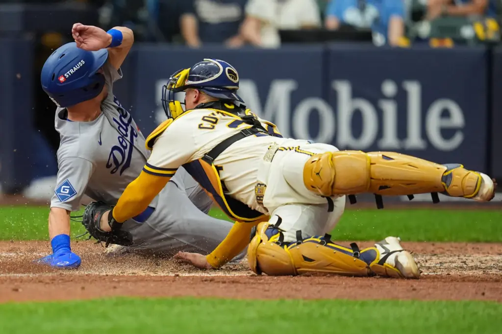 The Dodgers’ Tommy Edman, left, scores on a sacrifice fly...
