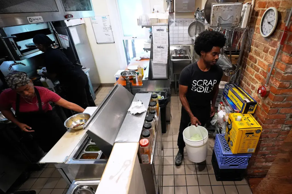 Ricky Blanding, founder of Scrap Soils, picks up compostable material...