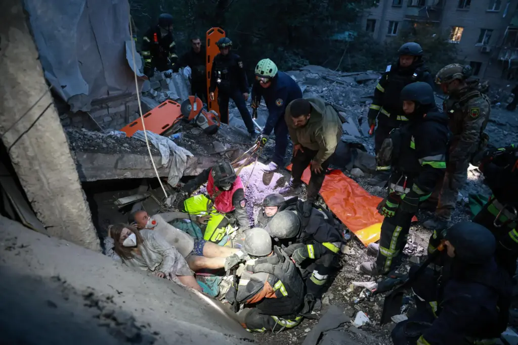 Rescue workers pull a family from the rubble of a...