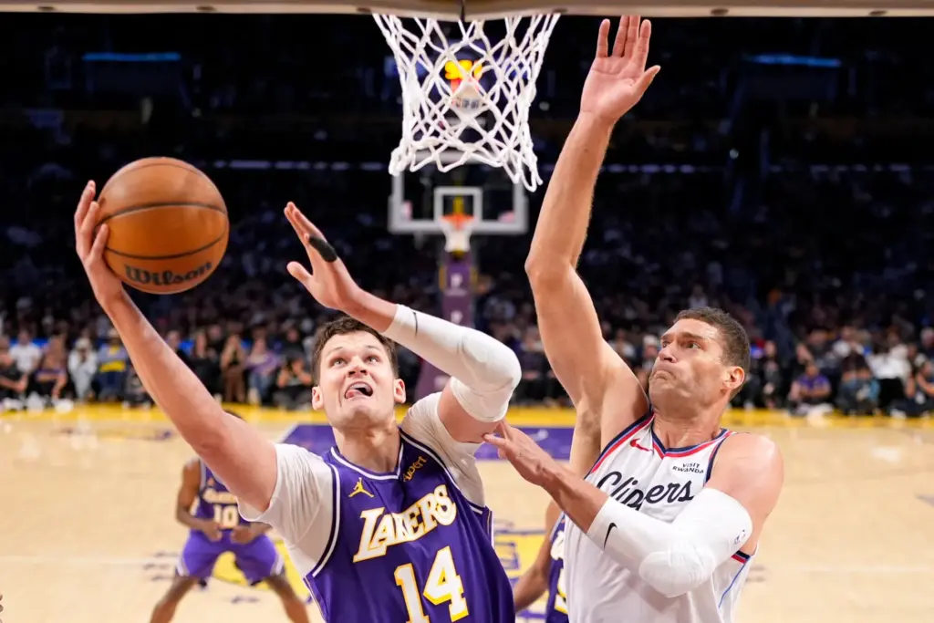 Lakers center Walker Kessler, left, shoots as Clippers center Brook...