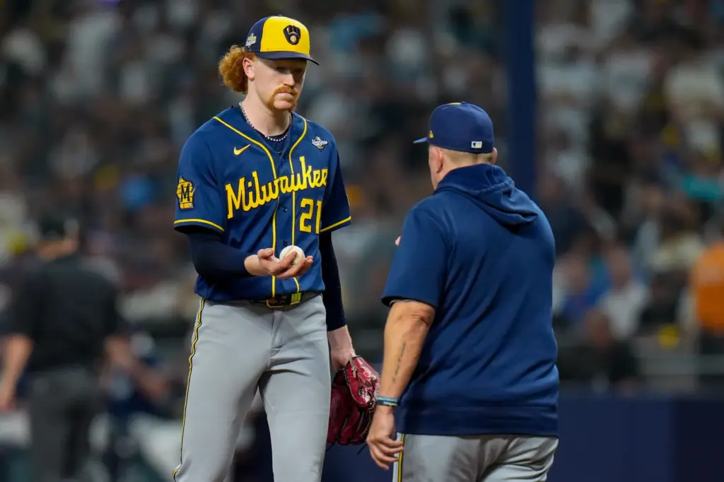 Milwaukee Brewers starting pitcher Dustin May, left, is removed by...