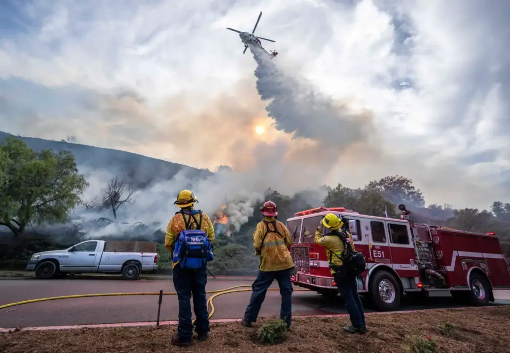 Orange County Fire Authority firefighters look on as a helicopter...