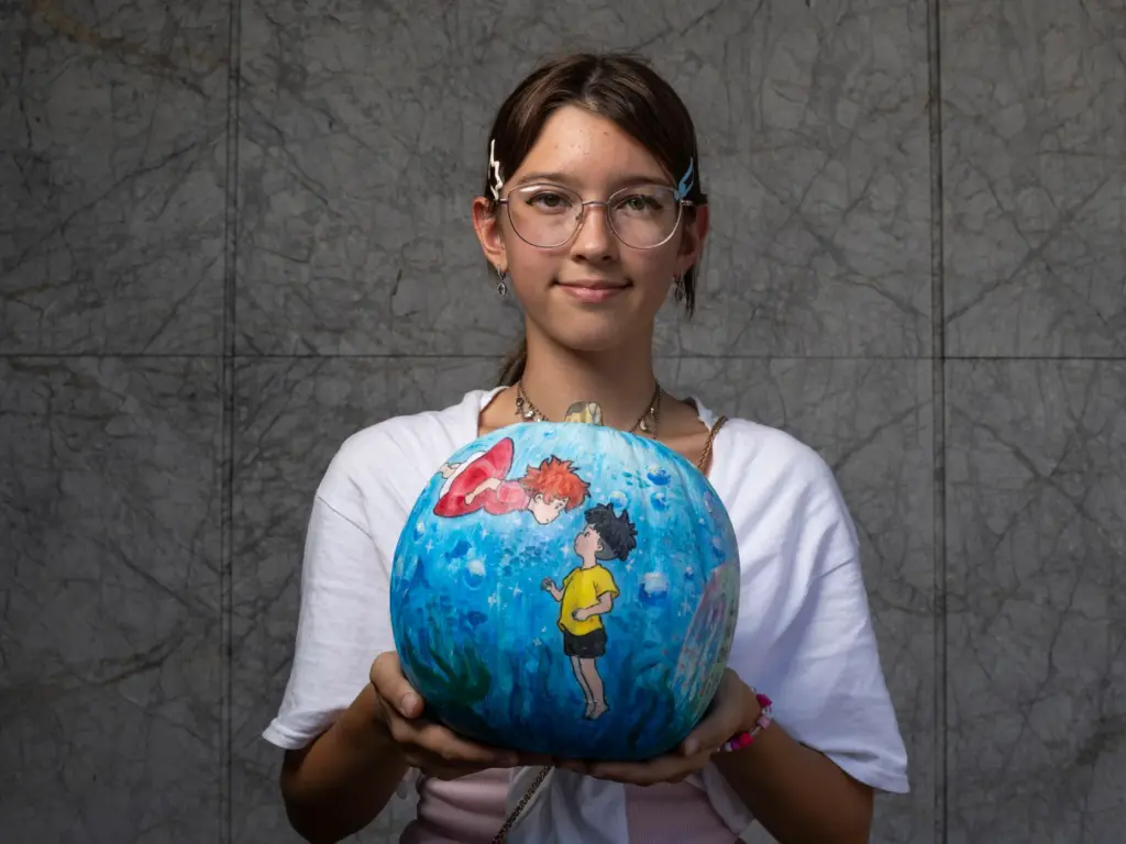 Daniela Slyusarenko holds her pumpkin titled âPonyoâ which she created...