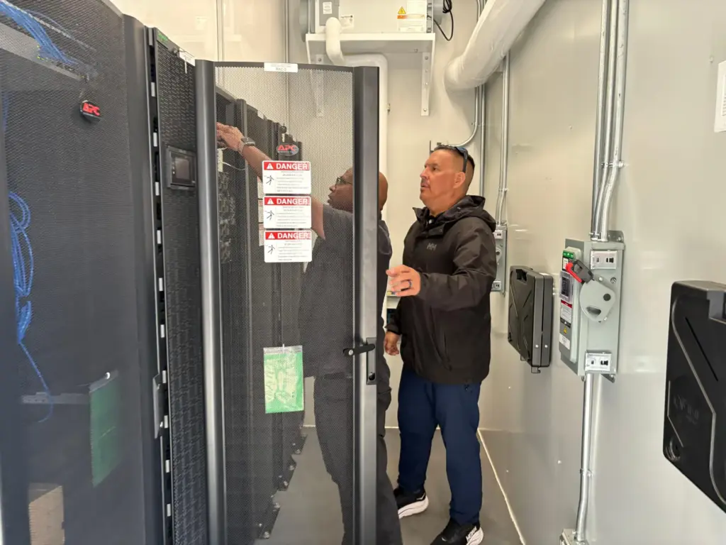 Wiikwemkoong's Chief Technology Officer Michael McCormick and a worker inspect the community's data center.