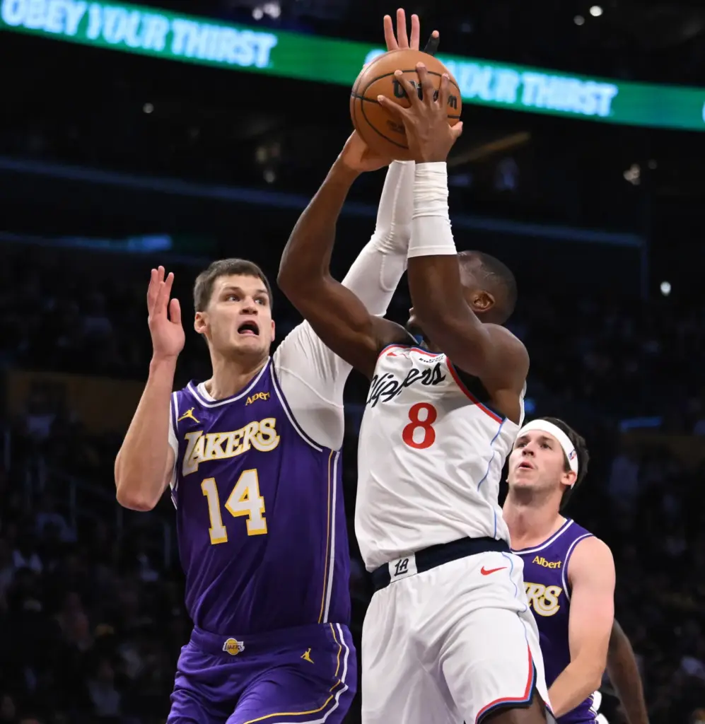 Lakers center Walker Kessler, left, blocks a shot by Clippers...