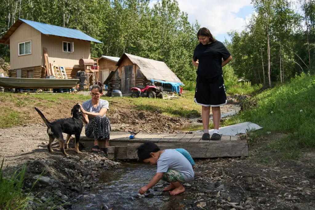 Lewis Thomas, front, plays in a creek as his cousin...