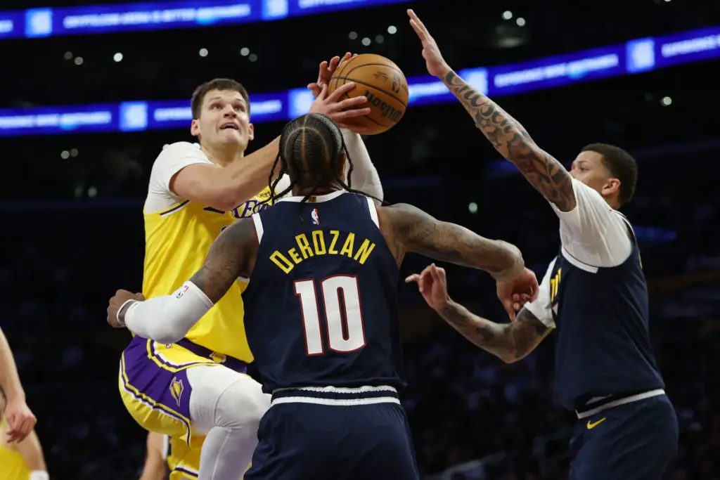 Lakers center Walker Kessler, left, drives to the basket as...