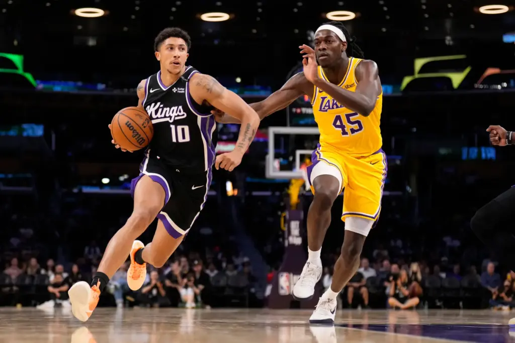 Sacramento Kings guard Nique Clifford, left, drives toward the basket...