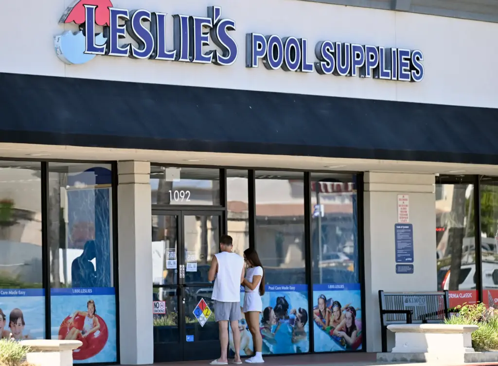 Customers, arrive at the doors of Leslieâs Pool Supplies in...