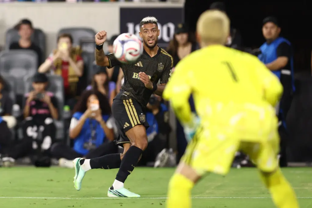 Los Angeles FC forward Denis Bouanga, back, watches his kicked...