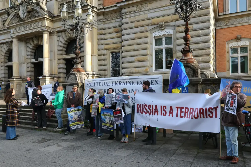 Ukraine supporters gather at the entrance to the Hanseatic Higher Regional Court.