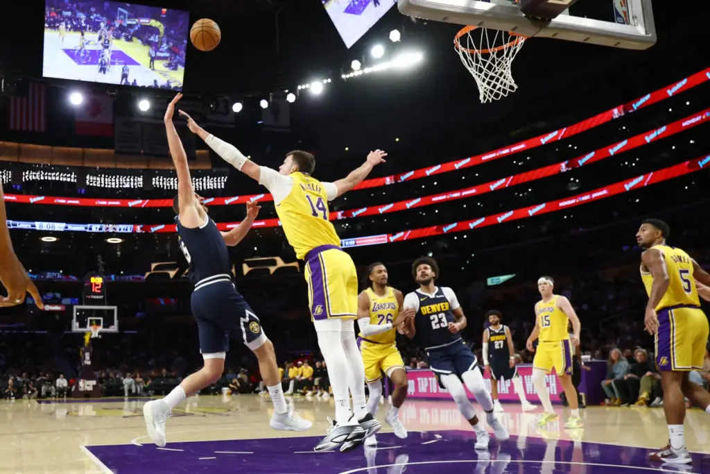 Denver Nuggets center Nikola Jokic, left, shoots as Lakers center...
