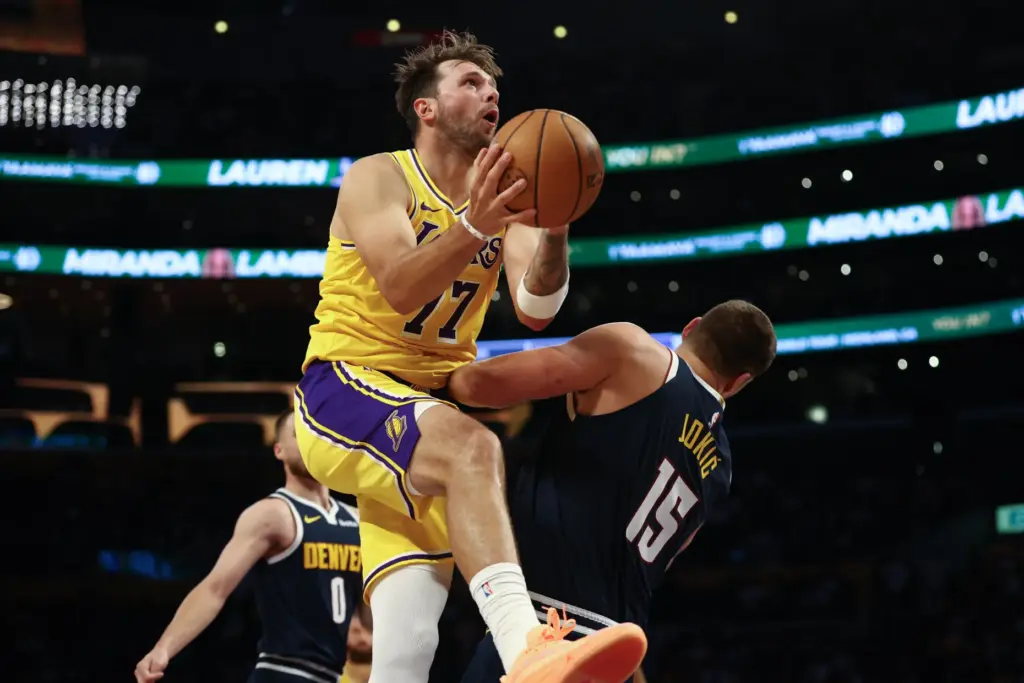 Lakers guard Luka Doncic, front left, drives into Denver Nuggets...