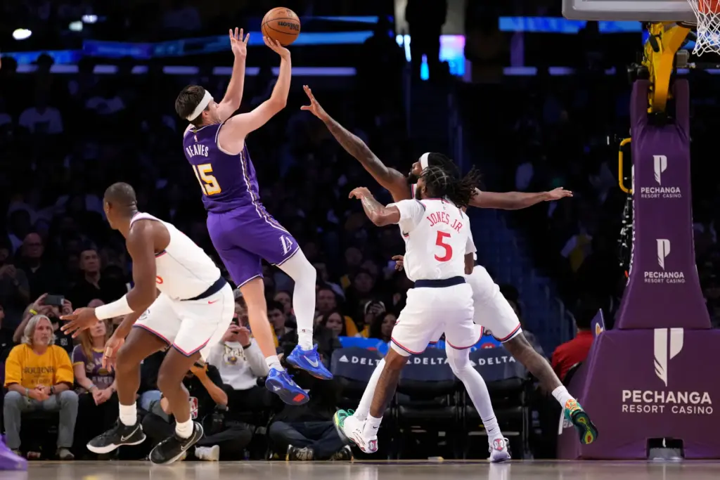 Lakers guard Austin Reaves, second from left, shoots as Clippers...