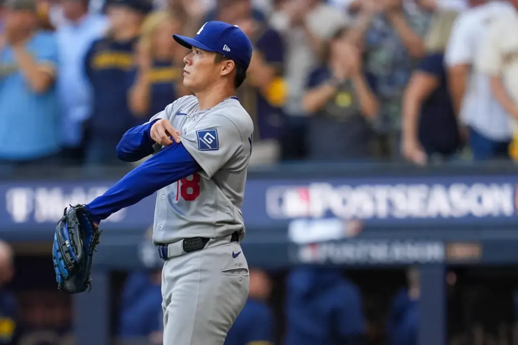 Dodgers starting pitcher Yoshinobu Yamamoto watches an RBI single by...