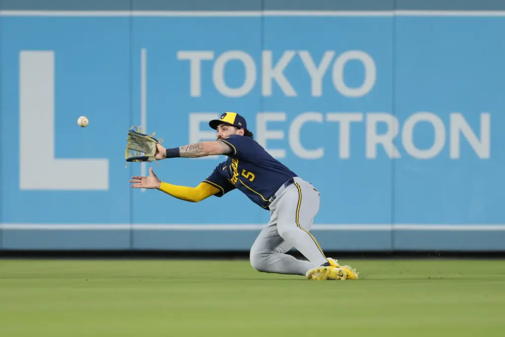 Milwaukee Brewers center fielder Garrett Mitchell dives to make a...