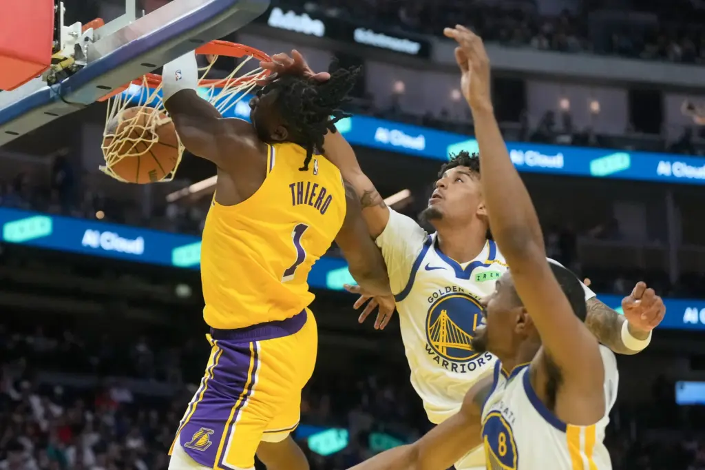 Lakers forward Adou Thiero, left, dunks as Golden State Warriors...