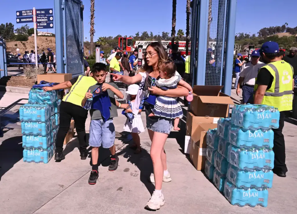 Fans receive a towel and a bottle of water as...