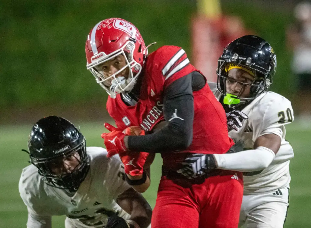 Orange Lutheran’s Nico Bland (8) battles for extra yardage during...