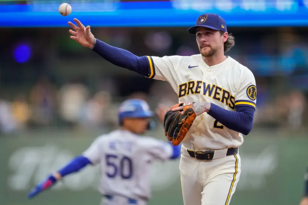 Milwaukee Brewers second baseman Brice Turang throws to first on...