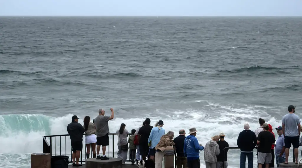 People gather to watch the pounding surf at Brooks Street...