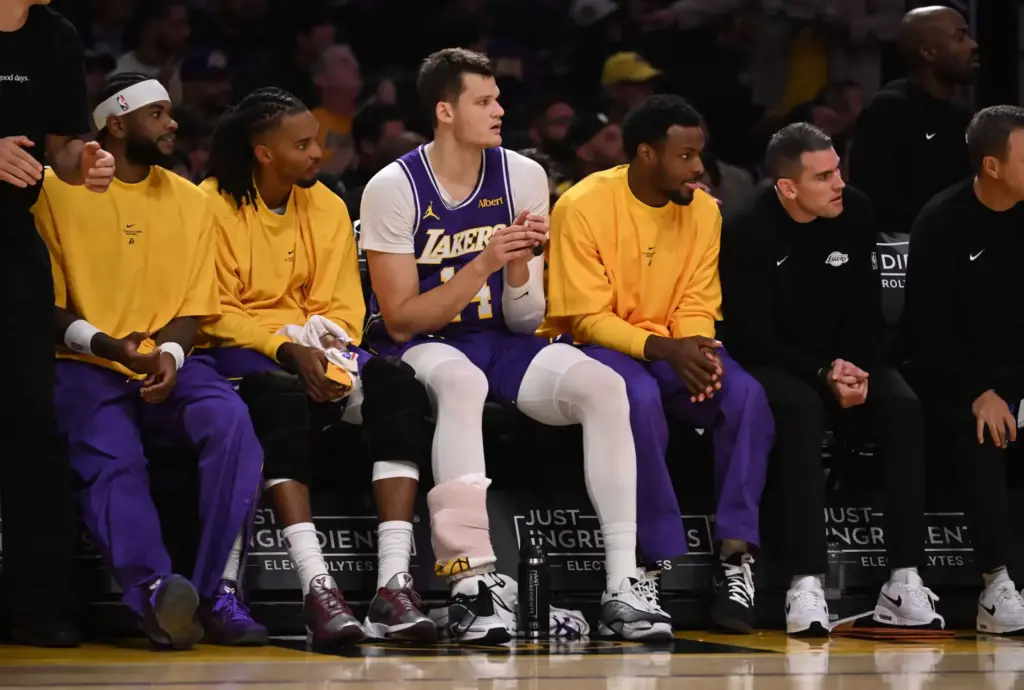 Lakers center Walker Kessler, middle, sits on the bench with...
