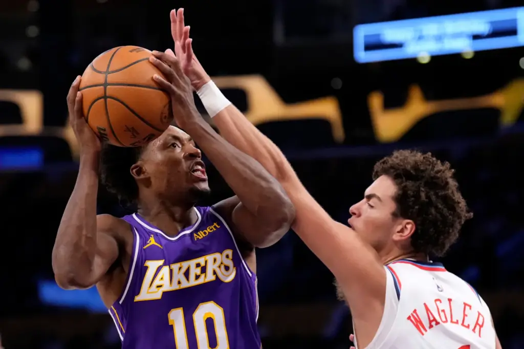 Lakers guard Collin Sexton, left, shoots as Clippers rookie guard...