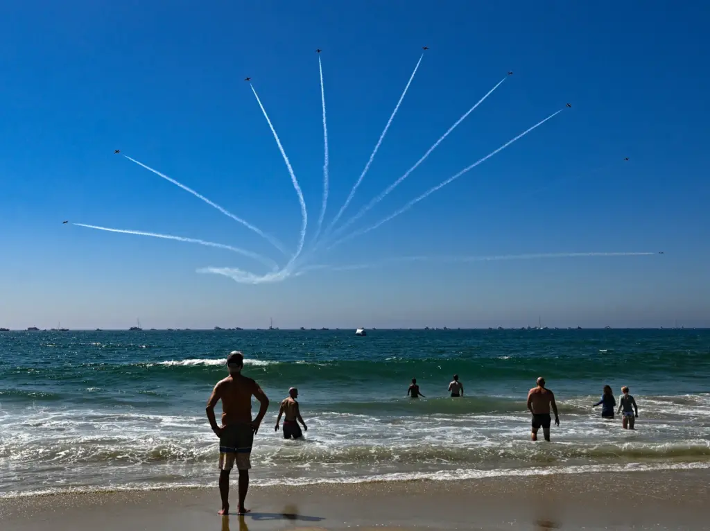 Beachgoers watch as The Canadian Forces Snowbirds perform during the...