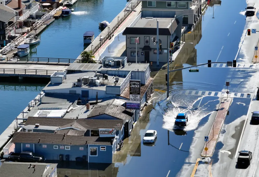 Sea water floods on to Pacific Coast Highway during high...