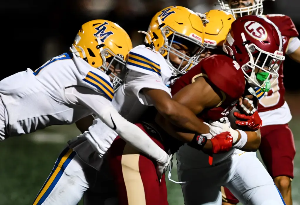 La Serna Lancers Kenai Summage (4) is tackled by La...