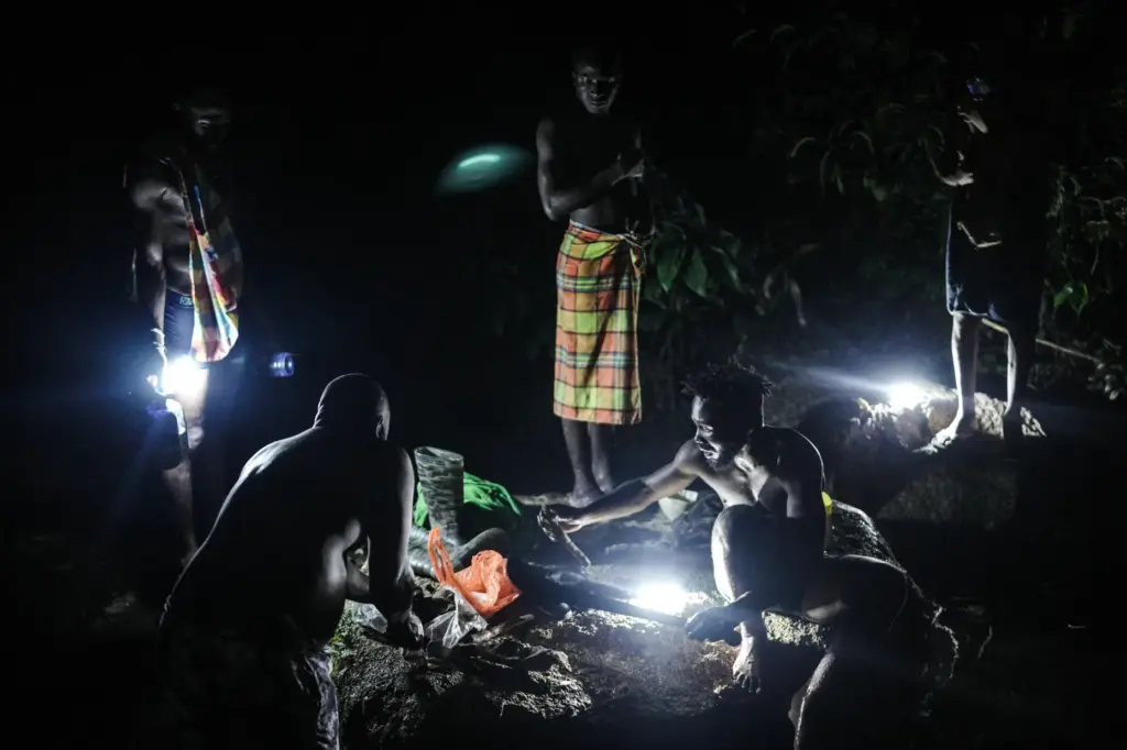 Members of the Saamaka community take a bath in a...