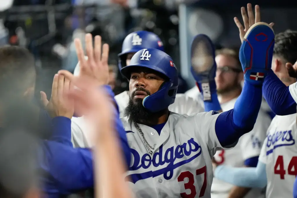 The Dodgers’ Teoscar HernÃ¡ndez celebrates in the dugout after scoring...
