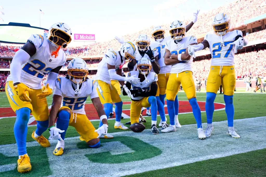 Chargers cornerback Cam Hart, center with ball, celebrates with teammates...