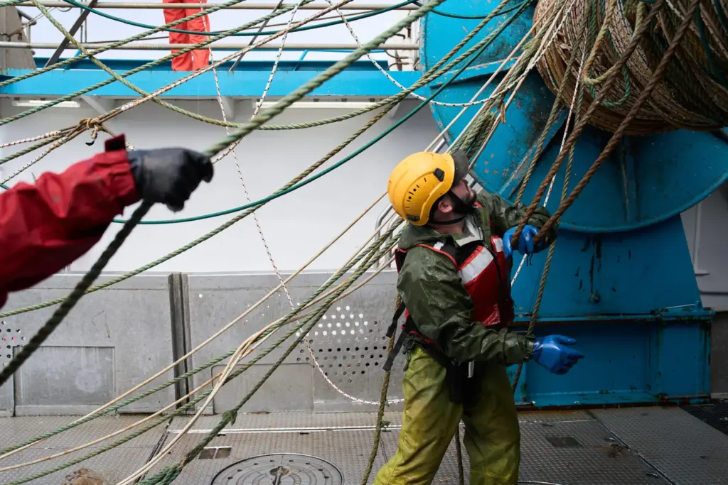 Crew members work aboard the F/V Progress in the Bering...
