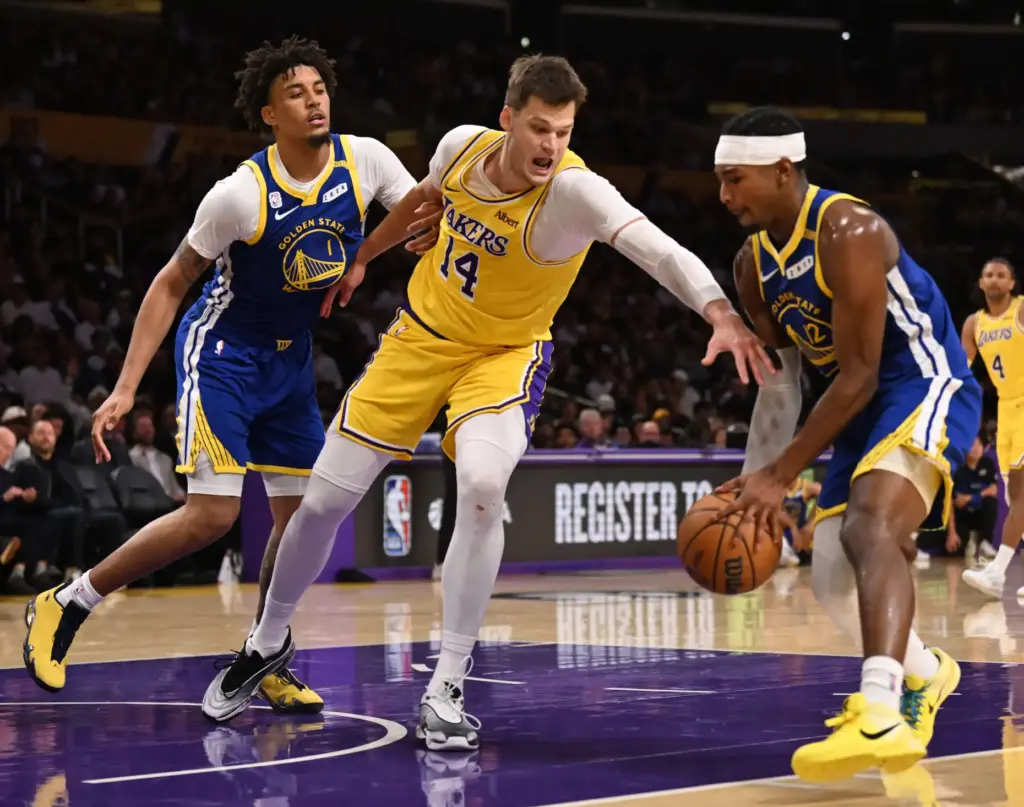 Lakers center Walker Kessler, middle, reaches for the ball as...
