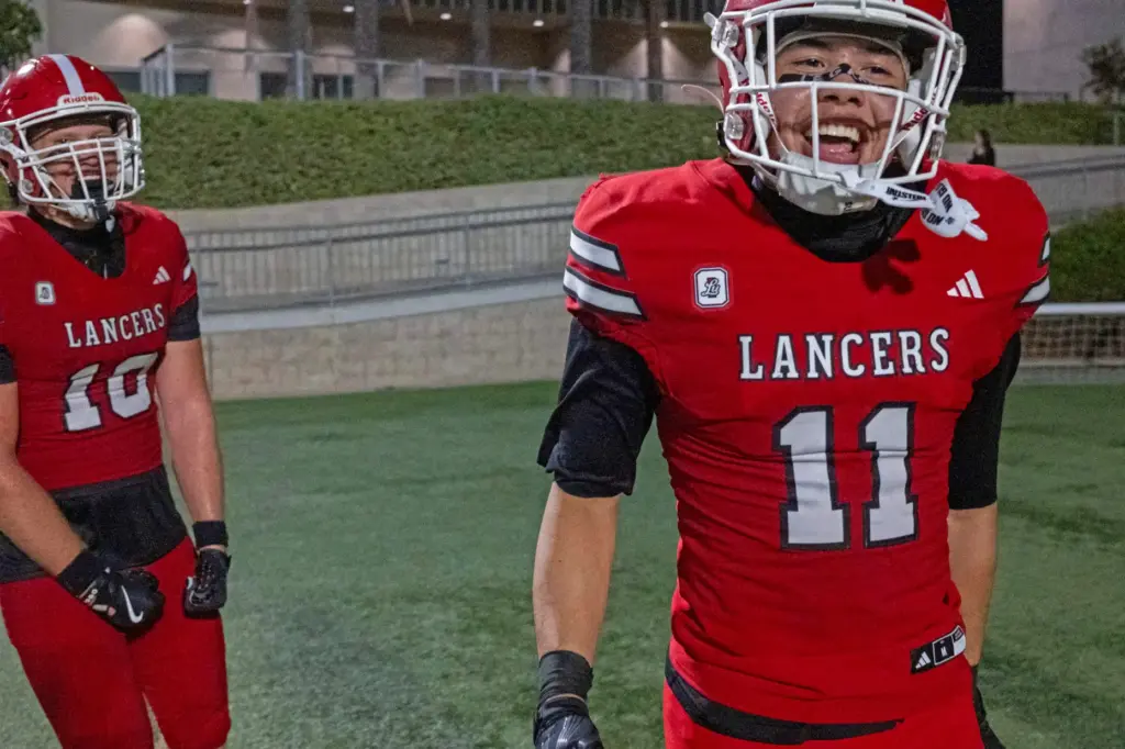 Orange Lutheran’s Raiden Velasquez (11) enjoys his touchdown with Orange...