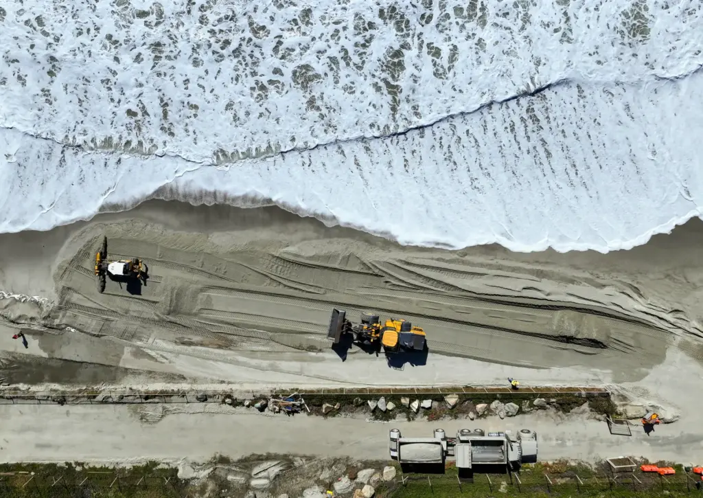 Truckloads of sand arrive at Capistrano Beach in Dana Point,...