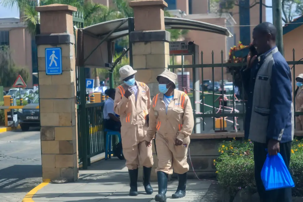 People put on masks at the entrance of The Nairobi...