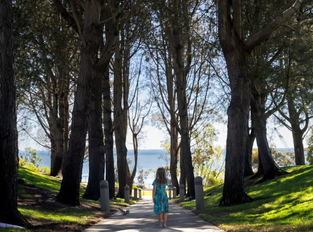 A girl watches a squirrel in the shade of Torrey...