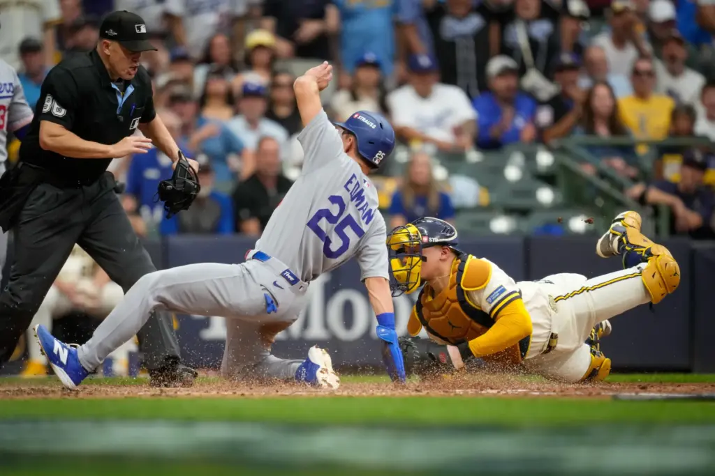 The Dodgers’ Tommy Edman, left, scores on a sacrifice fly...