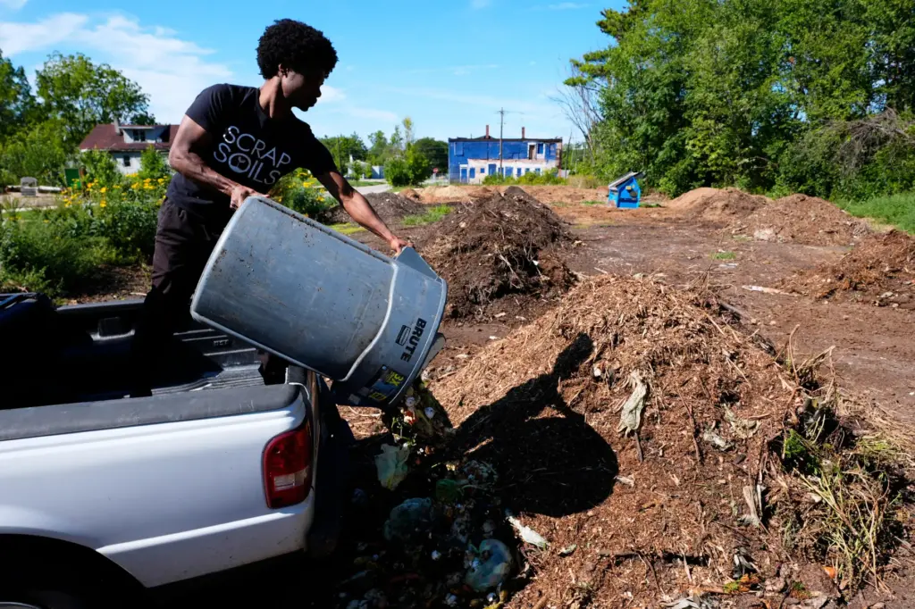 Ricky Blanding, founder of Scrap Soils, dumps compostable material at...