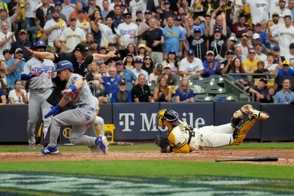 The Dodgers’ Tommy Edman, left, scores on a sacrifice fly...