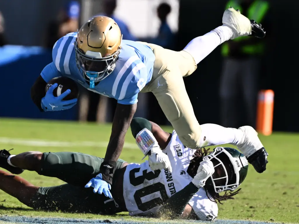 UCLA running back Anthony Woods (6) leaps over Michigan State...