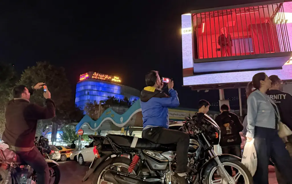 People take pictures of a billboard installation featuring an actor...