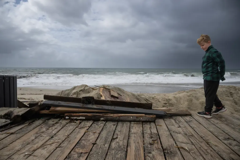 Wood debris is piled on the boardwalk of Laguna’s Main...