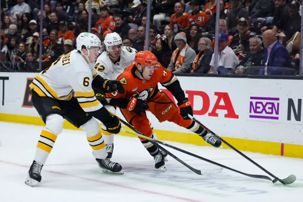 Ducks right wing Beckett Sennecke, right, skates against Boston Bruins...
